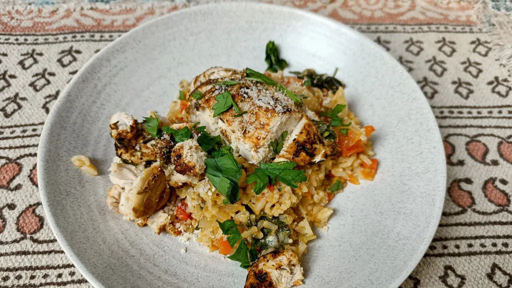 Photograph of Basil-parmesan chicken and rice with tomatoes.