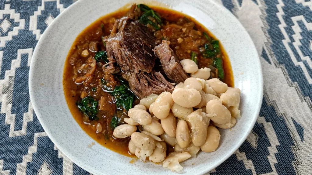 Photograph of Braised beef short ribs with butter beans and figs.