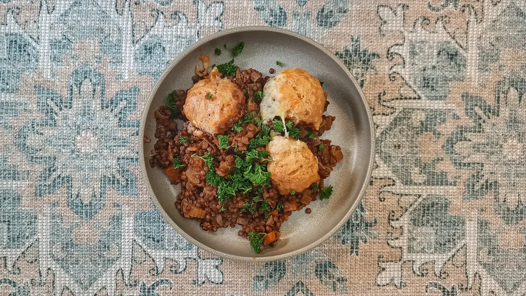 Photograph of Braised lentils with cheesy dumplings.