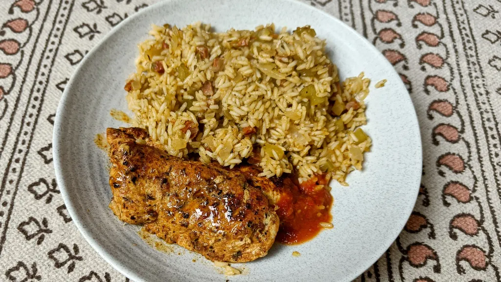 Photograph of Cajun blackened chicken with dirty rice.