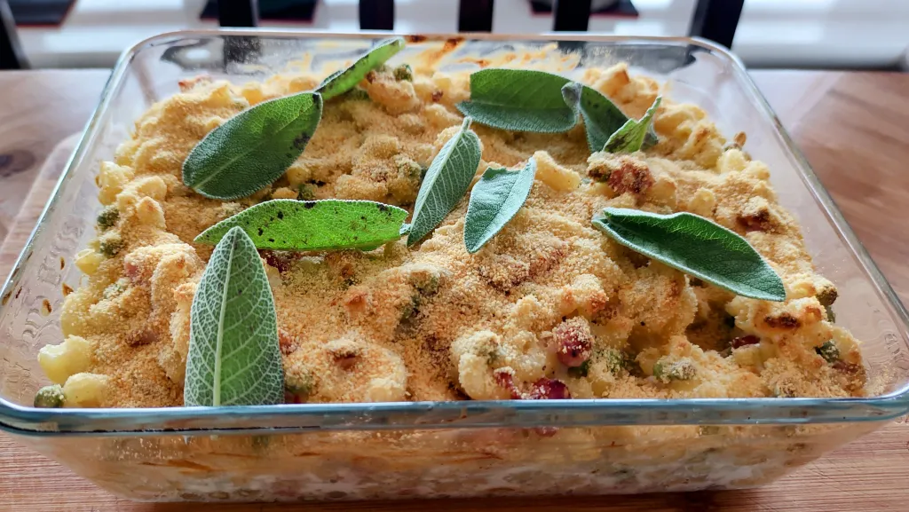 Photograph of Cheat's macaroni cheese with ham, peas and stilton.