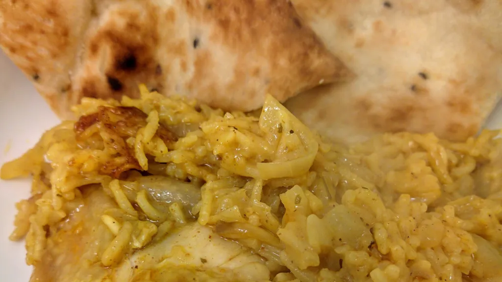 Photograph of Chicken biryani with naans.