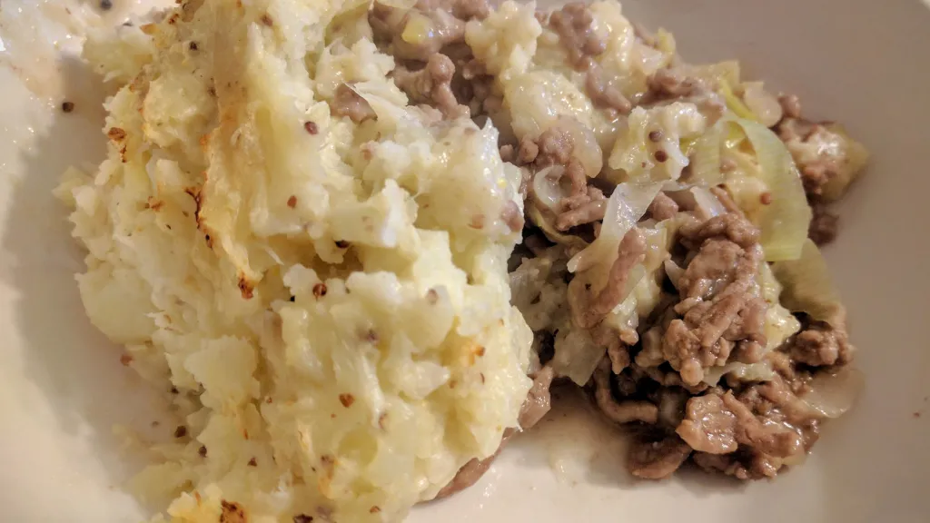 Photograph of Cider pork & bacon pie with cauliflower and potato mash.