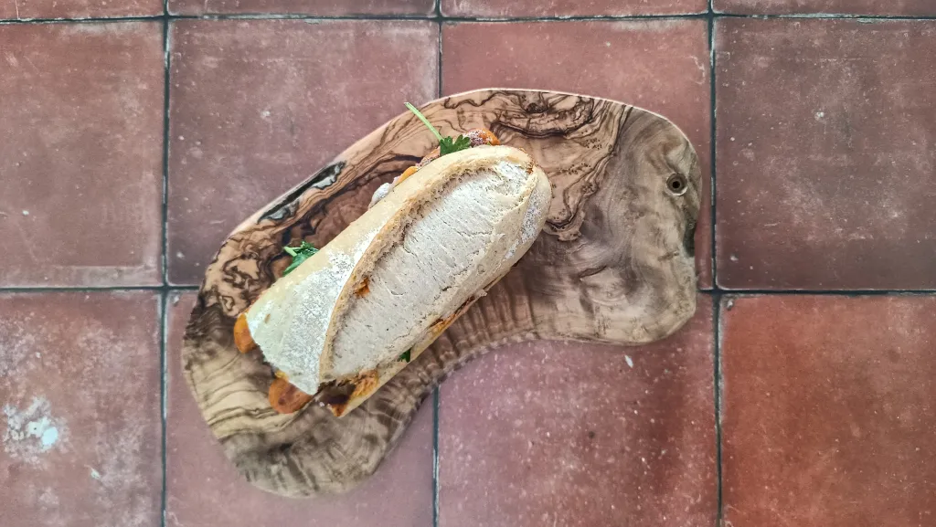 Photograph of Grilled merguez sandwiches with caramelized onions, manchego, and harissa mayonnaise.