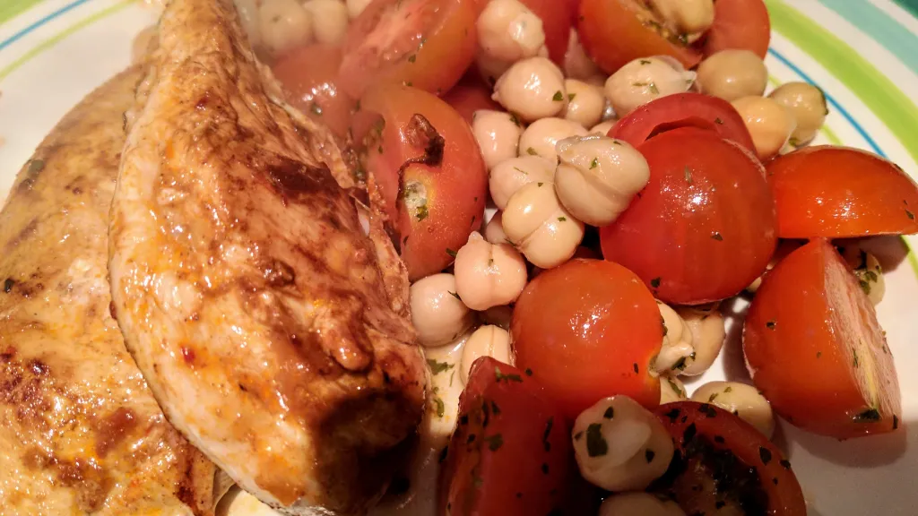 Photograph of Harissa chicken with chickpea salad.