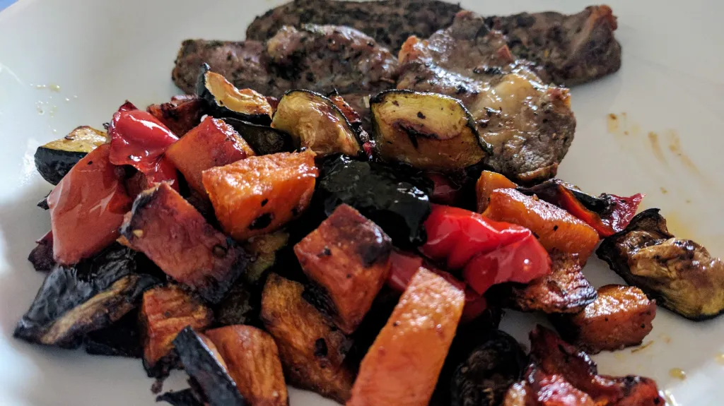 Photograph of Herbed lamb cutlets with roasted vegetables.