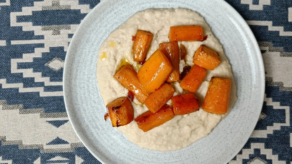 Photograph of Honey roast carrots with garlicky bean mash.