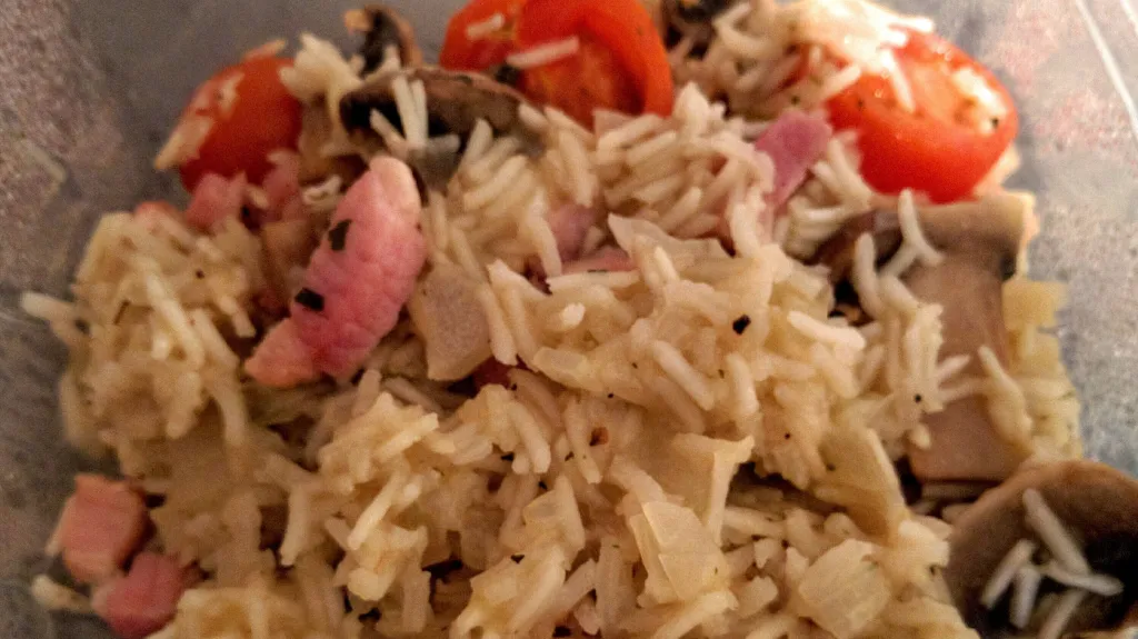 Photograph of One pot pancetta risotto with mushrooms and tomatoes.