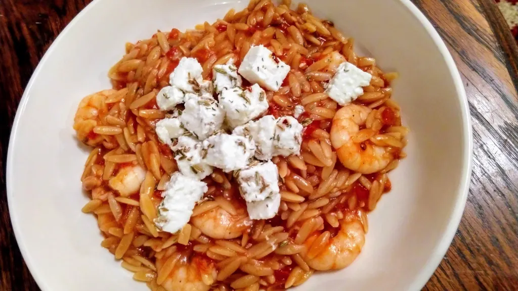 Photograph of Orzo with prawns, tomato and marinated feta.