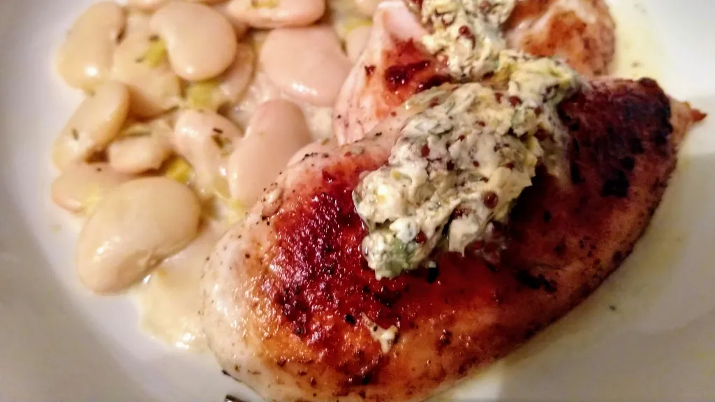 Photograph of Pan-fried chicken with creamy beans & leeks.