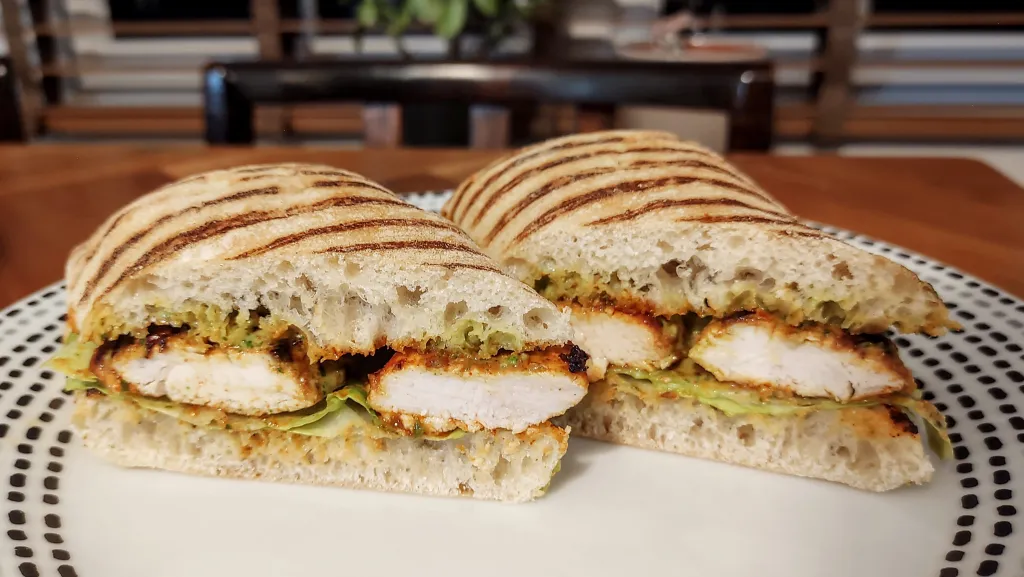 Photograph of Peruvian-style grilled-chicken sandwiches with spicy green sauce.