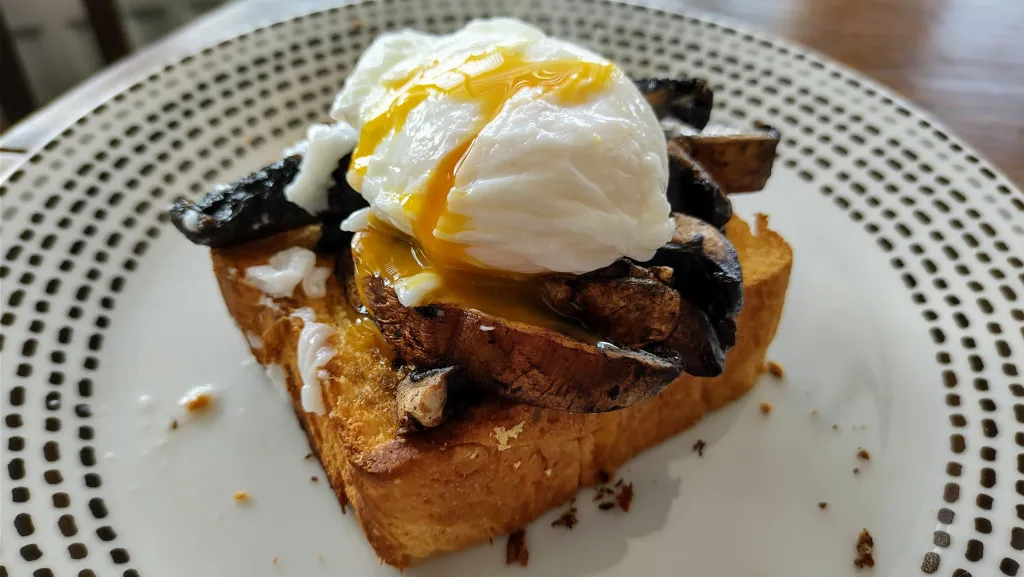 Photograph of Portobello mushrooms with brioche and a poached egg.