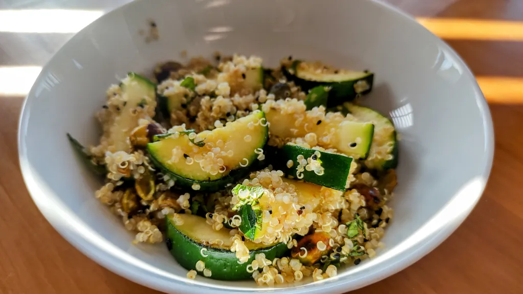 Photograph of Quinoa salad with toasted pistachios, preserved lemons and courgettes.