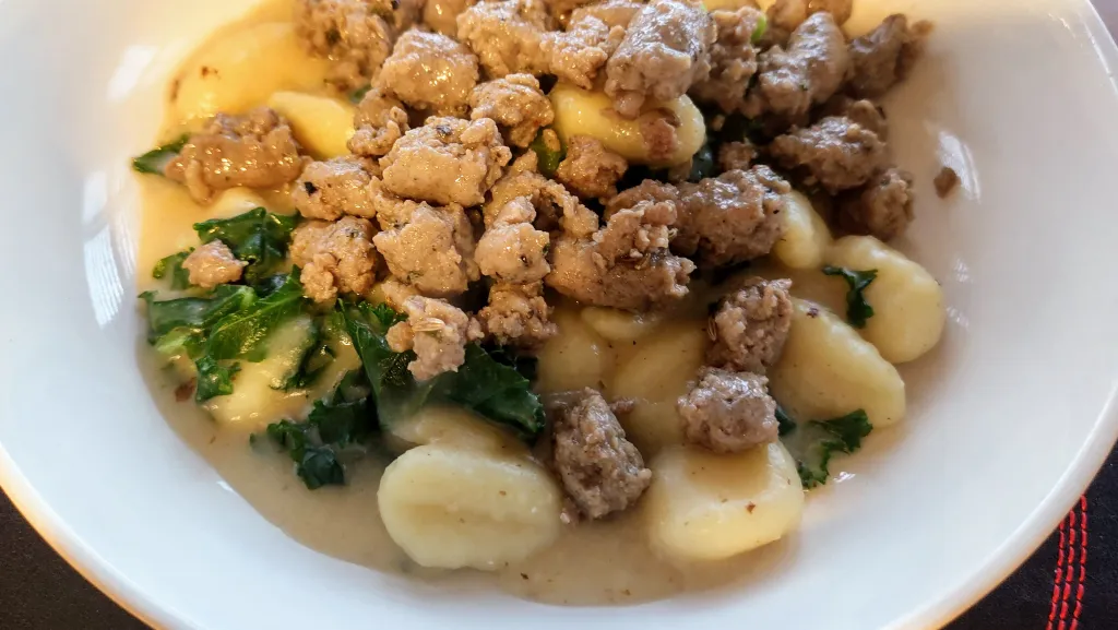 Photograph of Sausage, kale & gnocchi one-pot.