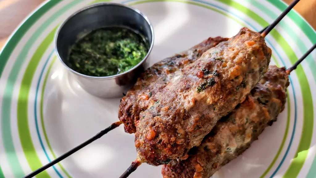 Photograph of Seekh kebab with mint chutney.
