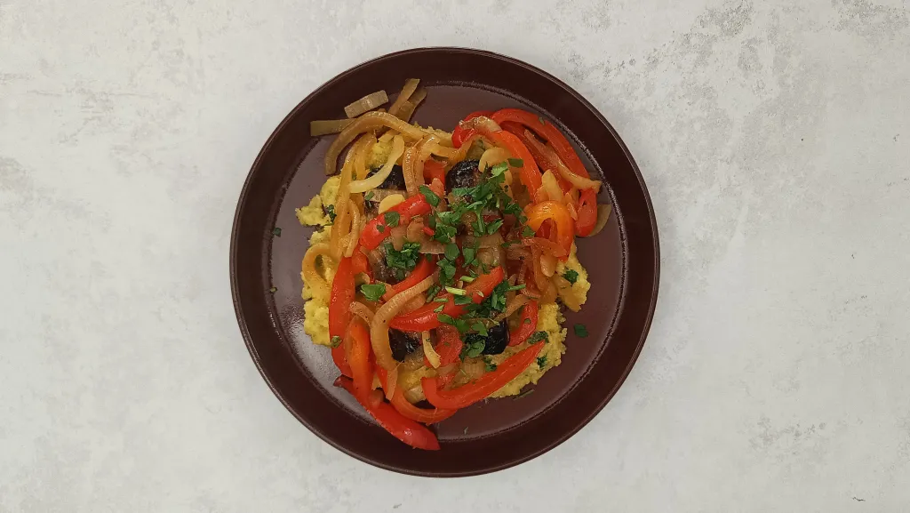 Photograph of Sicilian-style sausages and peppers with herby polenta.