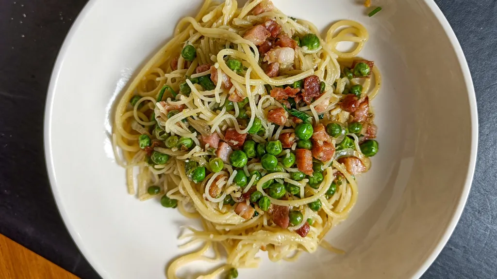 Photograph of Simple pancetta pasta with peas and parmesan.