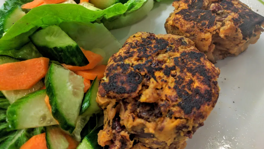 Photograph of Smoky sweet potato & bean cakes with citrus salad.