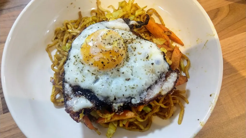 Photograph of Spicy noodles with spring onions & fried eggs.